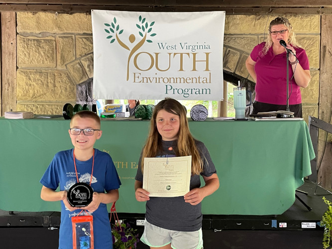 Two members of the Nichols Environmental Club from Cabell County pose for a picture while holding up their glass award and certificate.